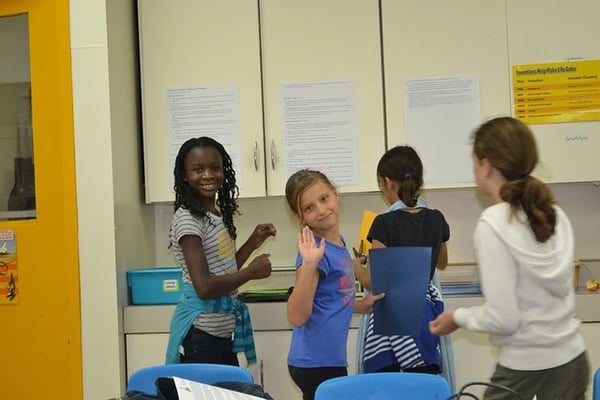Students looking at group assignments and roles for collaboration in the classroom.